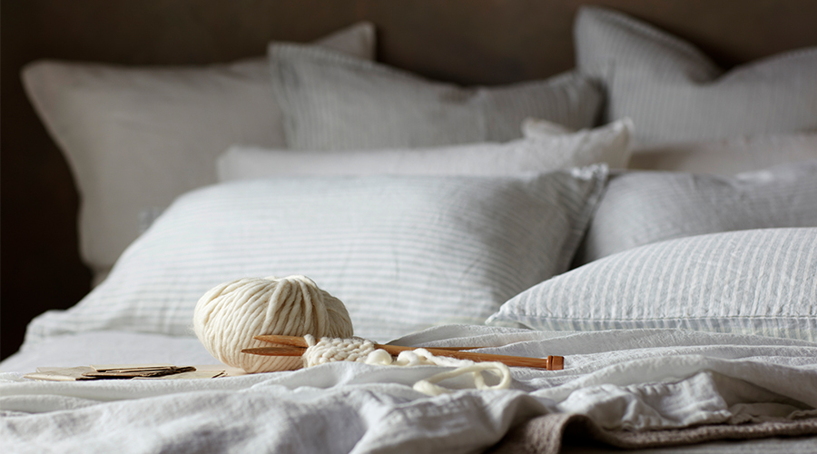 A Ball of Yarn on Top of Our Sage Stripe Linen Bedding